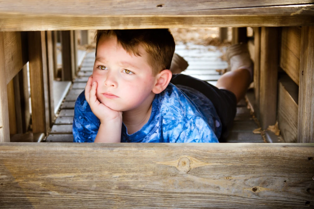 child under stairs on his own